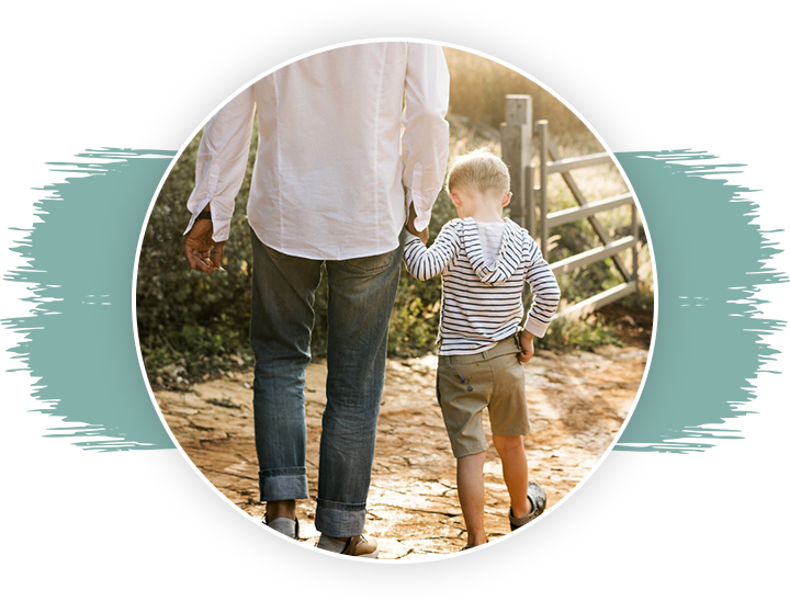 A man and boy walking on the sidewalk